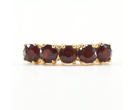 An Italian 18ct gold and garnet five stone ring. The ring set with five round mixed cut garnets to pinched shoulders and plai