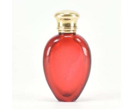A ruby glass &amp; yellow metal lidded perfume bottle. The bottle of reverse teardrop form having a hinged yellow metal lid w