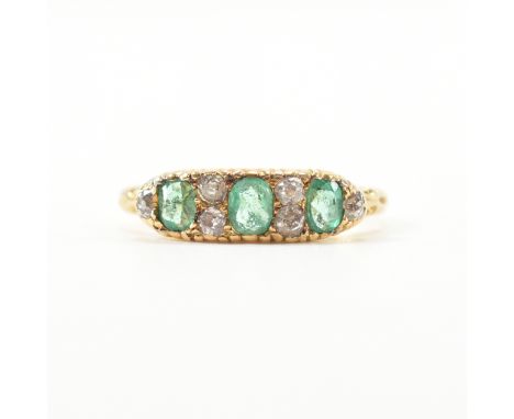 An 18ct gold emerald and diamond ring. The ring set with three oval cut emeralds and six old cut diamonds. Stamped 18ct. Insc