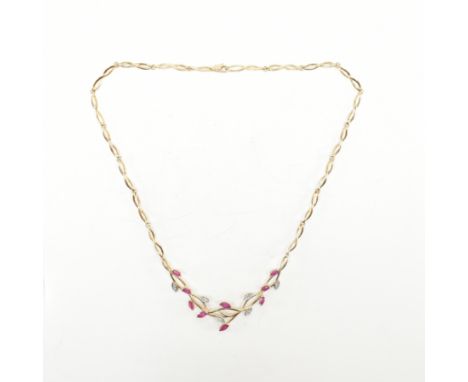 A hallmarked 9ct yellow gold, ruby &amp; diamond dress necklace. The necklace having a central pendant of openwork foliate de