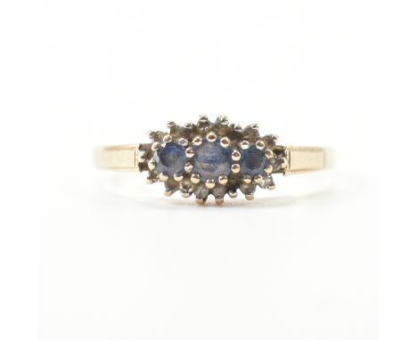 A hallmarked 9ct yellow gold, sapphire &amp; diamond cluster ring. The ring having three graduating round cut sapphires surro