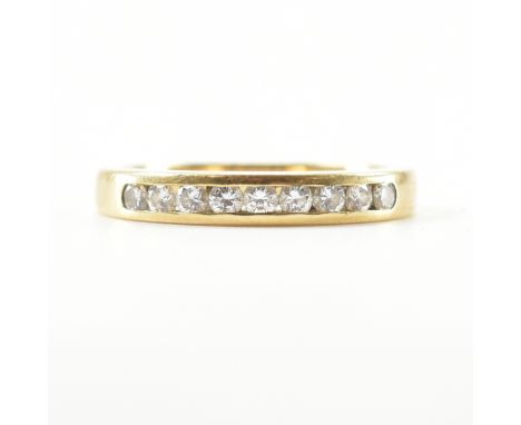 A hallmarked 18ct gold and diamond half eternity ring. The ring having 9 channel set round brilliant cut diamonds to plain sh