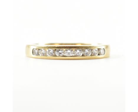 A hallmarked 18ct gold and diamond half eternity ring. The ring having 9 channel set round brilliant cut diamonds to plain sh