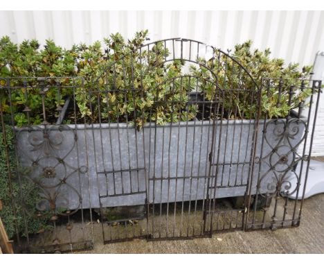 A wrought iron garden gate of small proportion, together with a pair of painted metal panels of scrolling foliate design