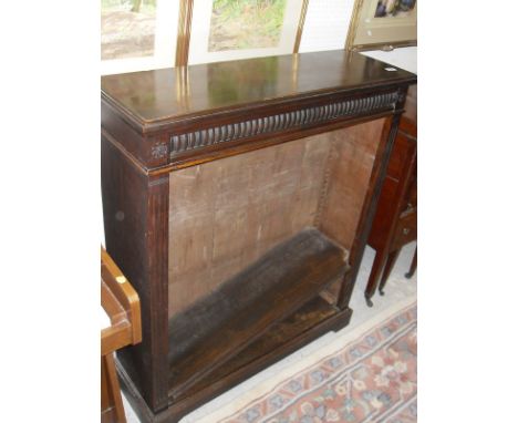 A late Victorian mahogany open bookcase, the plain top above a carved pediment to fluted column supports and two adjustable s