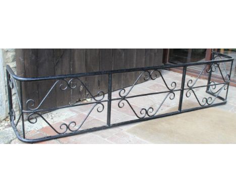 A black painted wrought iron fireguard of large proportions