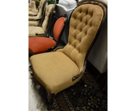 A Victorian rosewood framed spoon back nursing chair with pale gold upholstery, button back and serpentine front rail to cabr