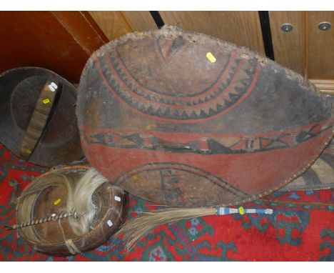 A collection of Ethnographica/Tribal items including two hide shields, two spears, fly whisks, hide bowl and cover and a wood