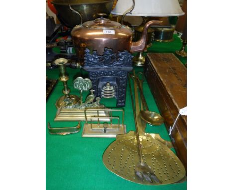 A Victorian copper kettle, brass lyre shaped trivet with wooden handle, 18th Century brass candlestick, miniature brass fende