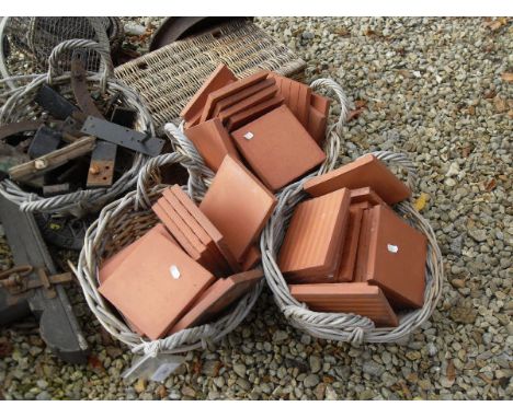 A collection of baskets, terracotta tiles, iron drain covers, iron wares, iron works etc, together with three wooden and wrou