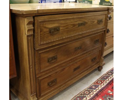 A 19th Century pine commode, the plain top above three long drawers with brass handles and column supports raised on ringed a