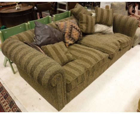 A modern three seat sofa with scroll arms and patterned striped brown upholstery with various scatter cushions