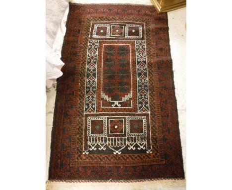 A Turkish prayer rug, the central panel set with architectural style panels on a dark red and black ground, within a stepped 