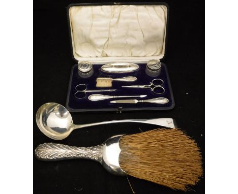 A George III silver ladle (London by Thomas Wilks Barber), a silver mounted brush (London by William Comyns) and a cased silv