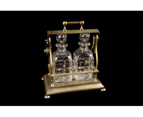 A plated two-bottle tantalus and pair of cut-glass decanters, bears inscription ‘Presented to Mr. T.S. Simpson by the platers