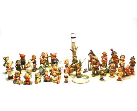 A collection of Goebel Hummel figures, including: a lamp modelled as a tree, with a boy sitting on a fence, 18cms high; a boy