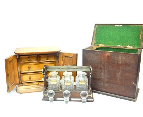 A Betjemanns of London three bottle Tantalus, fitted with three cut glass decanters with stoppers, each with silver plated la