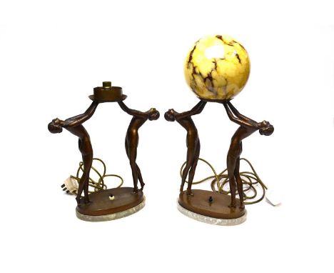 A pair of 1930s Art Deco bronze figural table lamps, each modelled with two dancers, one holding a marbled glass globe aloft,