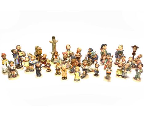 A collection of Goebel Hummel figures, including: a boy with a projector; a boy playing the accordion; a boy playing a drum; 
