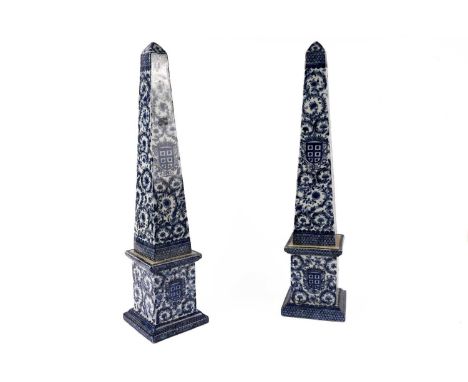 A pair of 19th Century style blue and white ceramic obelisks, with chinoiserie style decoration and crests, 64cms high.