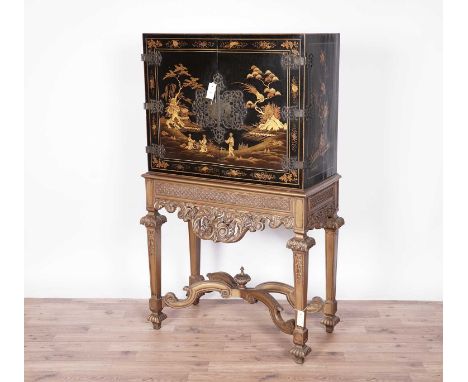 An Oriental lacquered parcel giltdrinks cabinet, the top section with cupboard doors, with pierced foliate hinges and lockpla