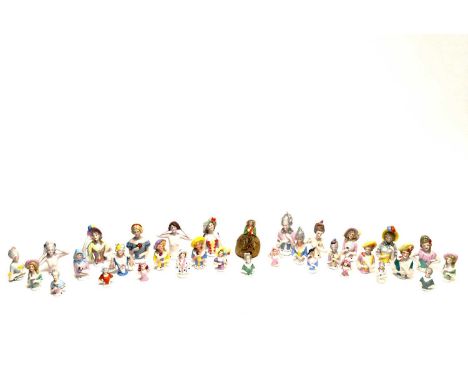 A collection of early 20th Century and later ceramic pin cushion dolls, modelled in various dress and poses, some nude, one a