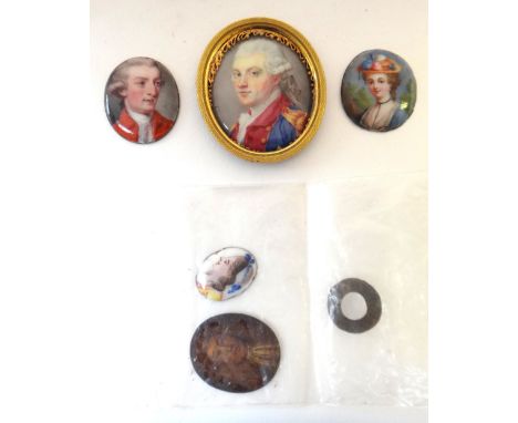 An early 19th century English School portrait miniature on enamel of a young man in a red coat, 2.5cms high; 3 other portrait
