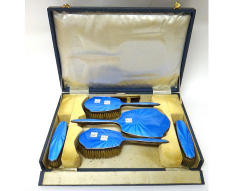 A lady's silver and blue enamel mounted five piece dressing set, comprising; a hand mirror, two hairbrushes and two clothes b
