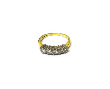 A gold and diamond set five stone ring, claw set with a row of circular cut diamonds, ring size K and a half, with a case.