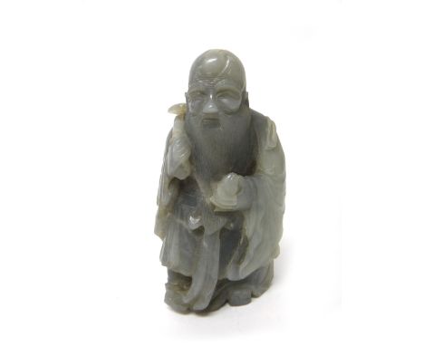 A Chinese jade figure of Shoulao, probably 19th century, carved standing holding a peach and ruyi sceptre, the stone of bluis