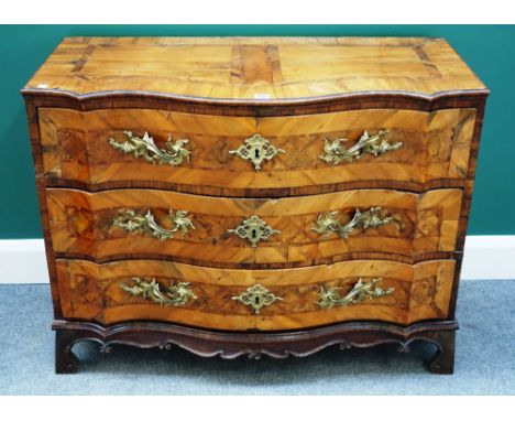 A 18th century German walnut serpentine three drawer commode, with carved frieze, on bracket feet, 102cm wide.