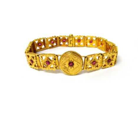 An Eastern gold and synthetic ruby set bracelet, the links in an engraved and pierced design and with a central circular pane
