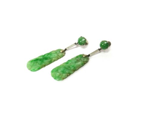 A pair of white gold and jade pendant earrings, each with a carved drop decorated with fruit motifs and with a circular surmo