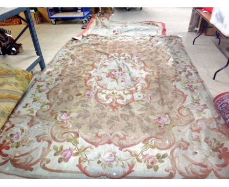 An Aubusson carpet, the beige field with an ivory cartouche of floral posy, shaped outer border of floral sprays, 383cm x 278