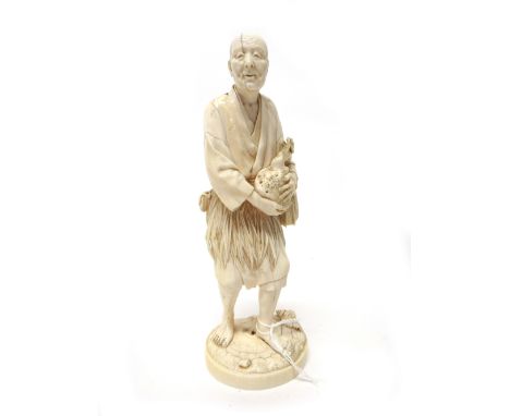 A Japanese ivory okimono of a man gathering coral by Ju/Toshi, Meiji period, standing with shells at his feet holding a branc