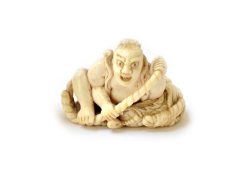 A Japanese ivory netsuke, Meiji period, carved as a grimacing seated man holding a rope, signed, 5cm. wide, signed. Illustrat