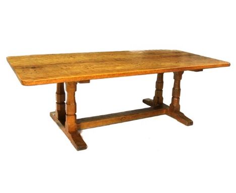 A 20th century oak refectory table, the adze plank top with pegged biscuit joints, on four baluster octagonal columns united 