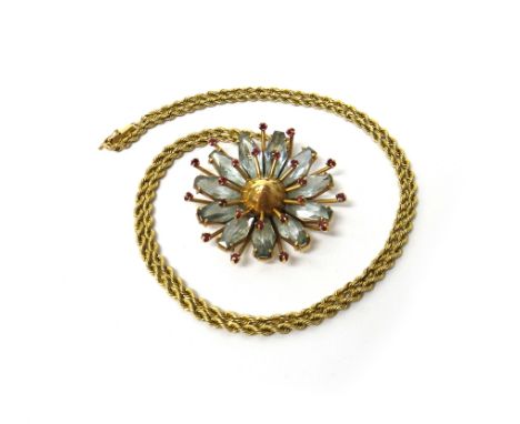 A gold, aquamarine and ruby pendant, designed as a flowerhead, mounted with two rows of small circular cut rubies enclosing t
