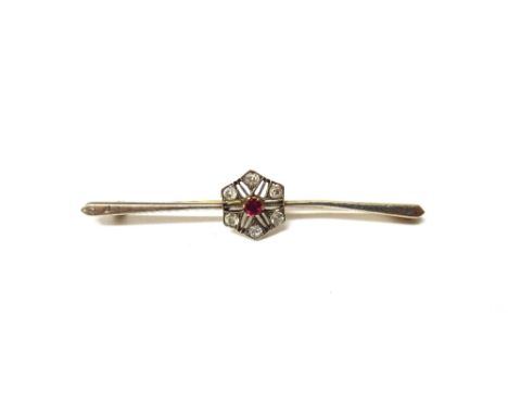 A gold, diamond and ruby set cluster bar brooch, in a pierced hexagonal design, mounted with the circular cut ruby at the cen