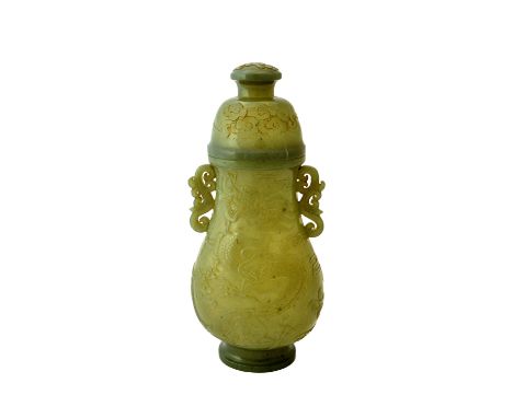 A Chinese jade pear shaped two-handled vase and cover, 19th century, each side carved with a writhing dragon, the domed cover