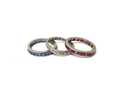 A diamond set full eternity ring, mounted with circular cut diamonds, ring size P and a half, a ruby set full eternity ring, 