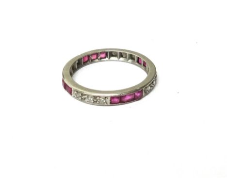 A diamond and ruby full eternity ring, mounted with rows of three circular cut diamonds alternating with rows of three calibr