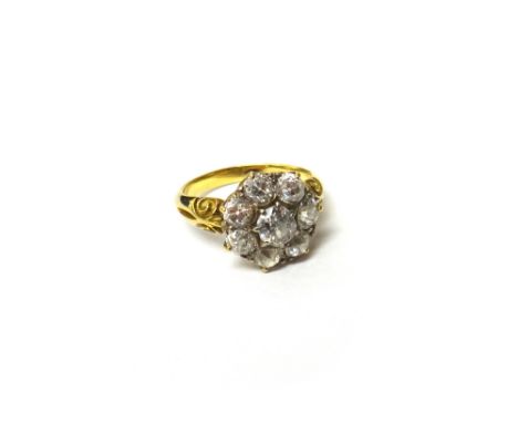 A gold and diamond set seven stone cluster ring, claw set with the principal cushion shaped diamond at the centre, in a surro