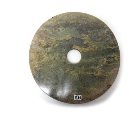 A very large jade bi disc, of plain circular form, the stone of green tone with brown, cream and grey inclusions, 39cm.diamet