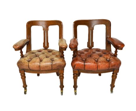 A pair of Victorian oak open arm tub back office chairs, with button rouge leather upholstered bowfront seats, on turned supp