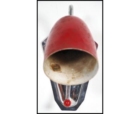 A vintage mid 20th century wall light having a chrome back with switch and a red pendant shade.