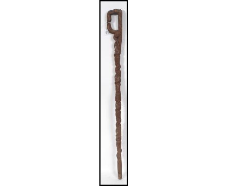 A carved wood walking stick, possibly Polynesian, the knob in the form of a stylised head, the haft with geometric designs ov