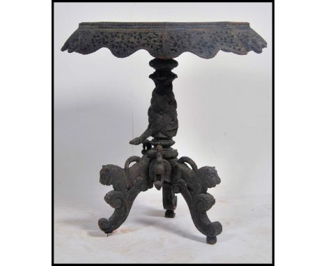 A 19th century intricately carved Anglo Indian Padouk occasional table, carved with birds, pierced scalloped skirt with heavi