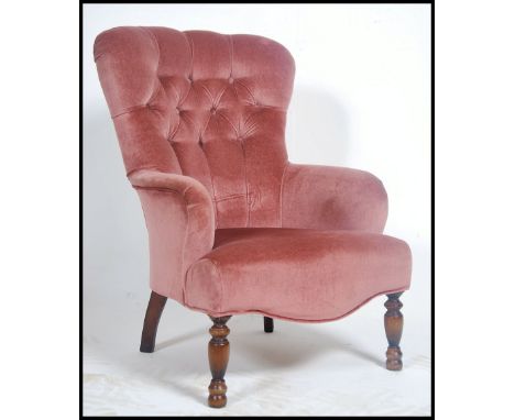 A Laura Ashley velour upholstered Victorian style armchair raised on turned legs with button backed upholstery