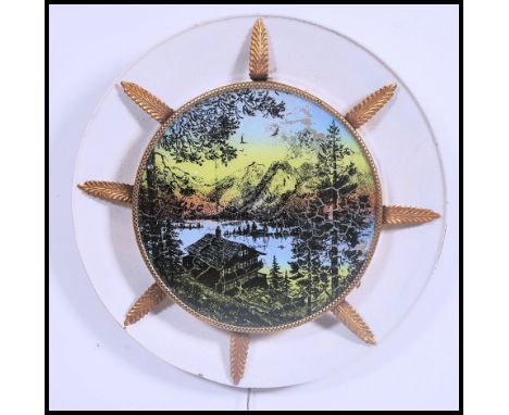 A retro mid century wall light with Scandinavian scene with backlight in plastic and gilded frame 